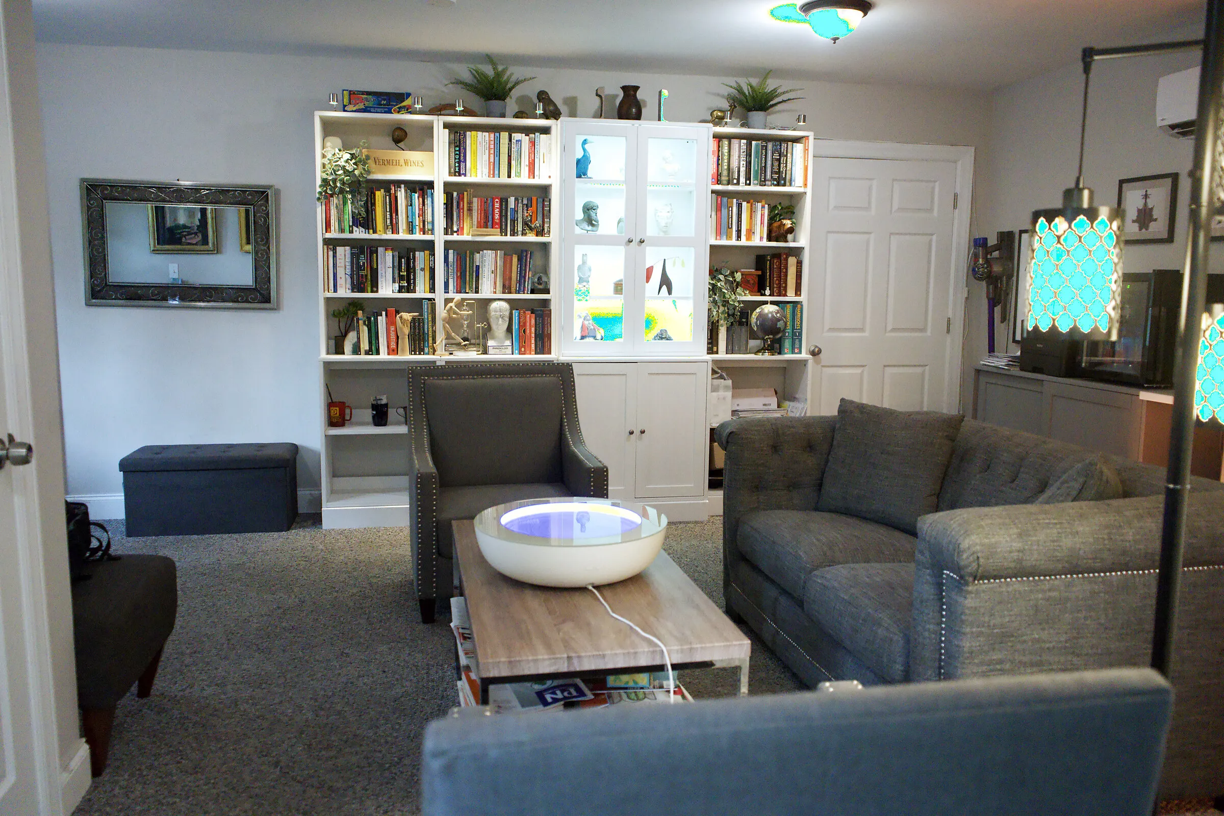 Bookshelves and a reading nook at the Chadds Ford office, with warm lighting and curated objects